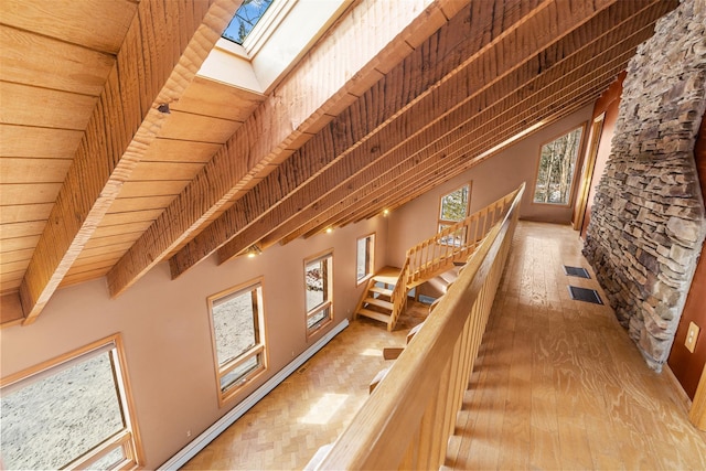 interior space with beam ceiling, wooden ceiling, wood-type flooring, and a skylight