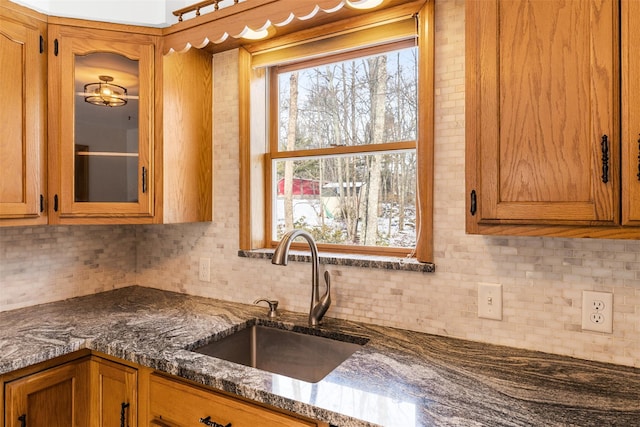 kitchen with sink, dark stone countertops, and tasteful backsplash