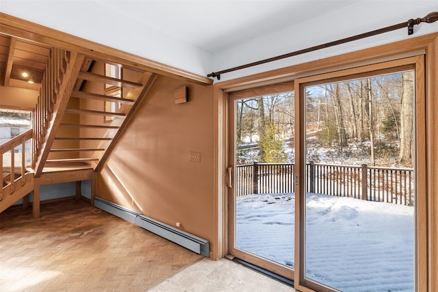 doorway to outside featuring baseboard heating and light parquet flooring