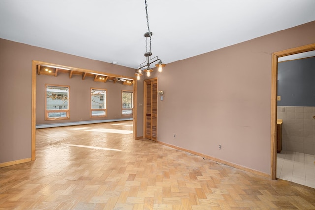 spare room featuring light parquet flooring and a baseboard heating unit