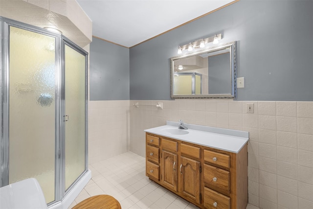 bathroom featuring vanity, tile walls, a shower with door, and tile patterned flooring