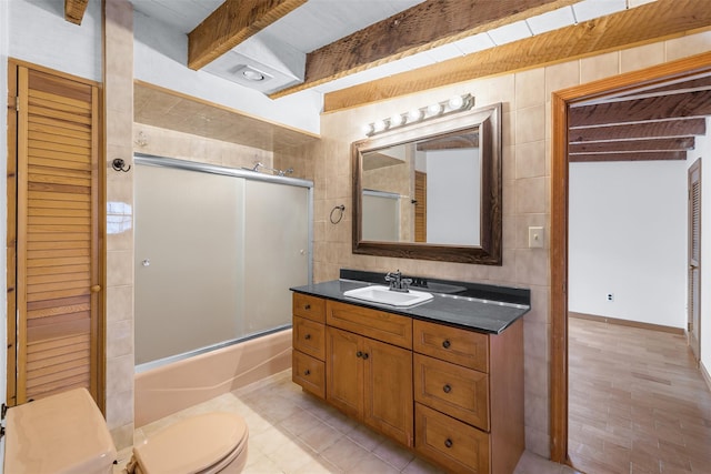 full bathroom featuring enclosed tub / shower combo, vanity, tile walls, toilet, and beam ceiling