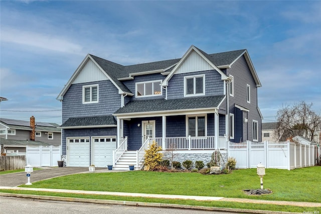 view of front of home with a garage, a front lawn, and a porch