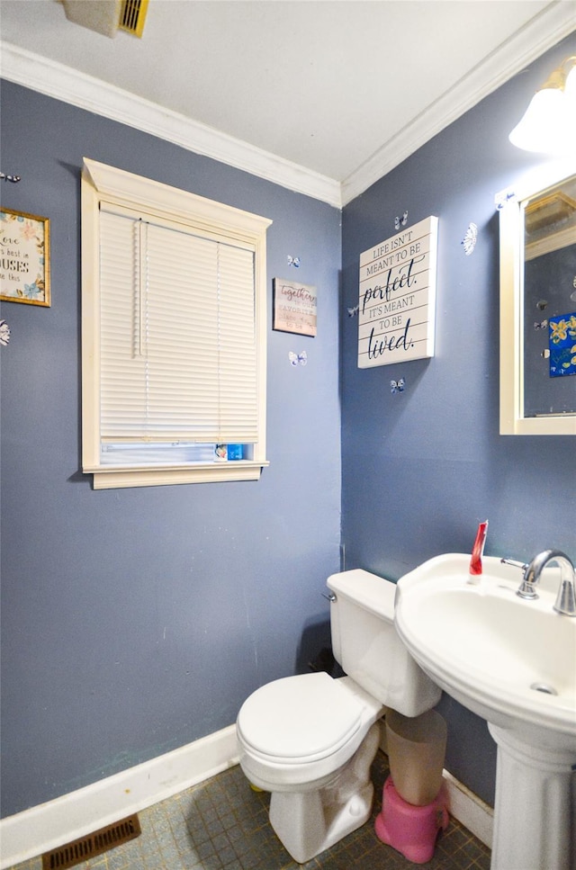 bathroom with tile patterned flooring, ornamental molding, and toilet