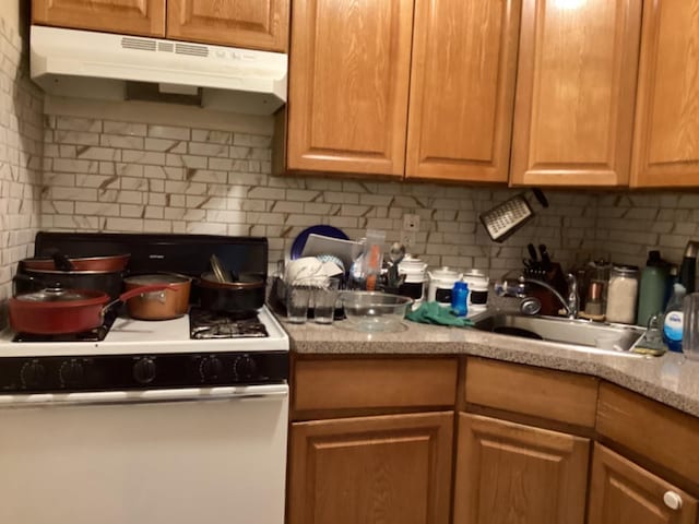 kitchen with sink, white range with gas cooktop, and tasteful backsplash