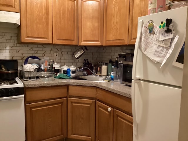 kitchen with sink, white refrigerator, stove, and tasteful backsplash