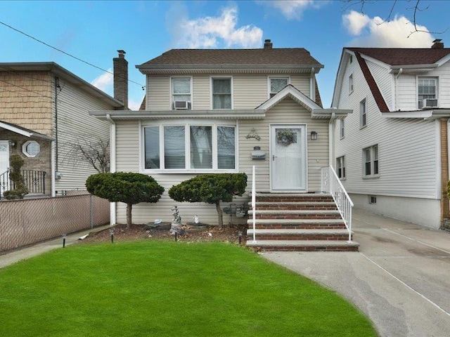 view of front facade featuring a front yard and cooling unit