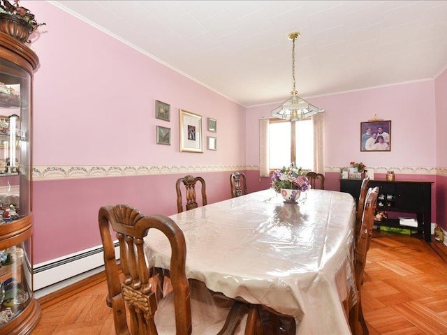 dining area featuring light parquet floors, a chandelier, ornamental molding, and a baseboard radiator