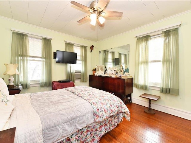 bedroom with hardwood / wood-style floors, ceiling fan, and ornamental molding