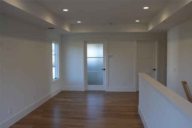 unfurnished room with dark wood-type flooring and a raised ceiling