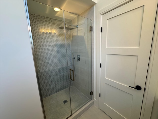 bathroom with tile patterned flooring and a shower with shower door