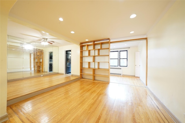 unfurnished living room with ceiling fan, radiator heating unit, and wood-type flooring