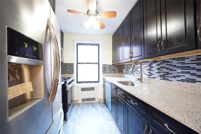 kitchen featuring sink, appliances with stainless steel finishes, radiator, light stone countertops, and decorative backsplash