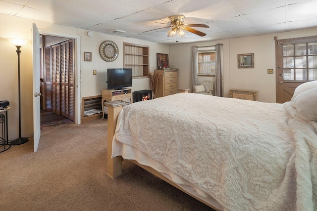 carpeted bedroom with a drop ceiling and ceiling fan