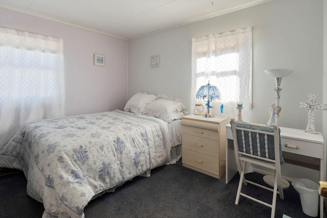 bedroom featuring ornamental molding and dark carpet