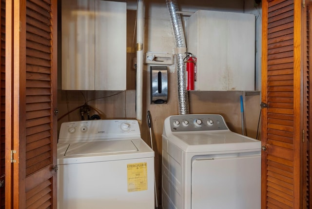 laundry room with cabinets and washing machine and clothes dryer