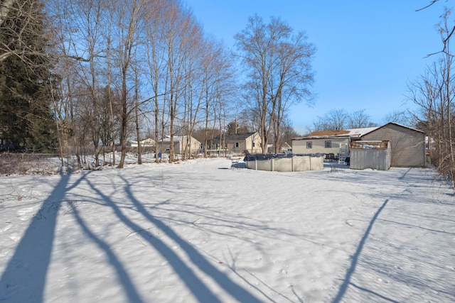 yard covered in snow with a covered pool