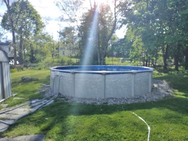 view of pool with a lawn