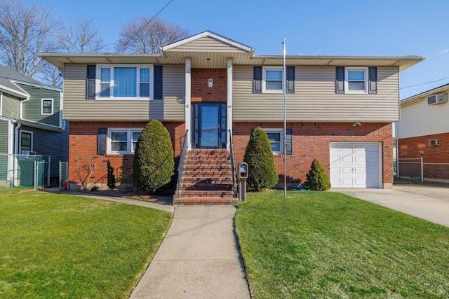 raised ranch featuring a garage, a front yard, and a wall unit AC