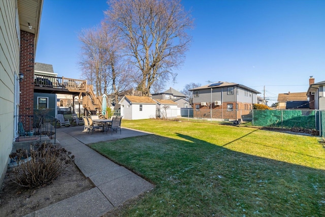 view of yard featuring a patio area, a wooden deck, and a storage shed