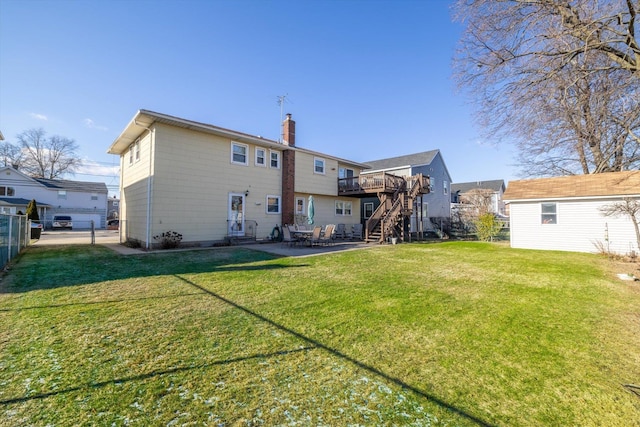 back of house featuring a deck, an outbuilding, a yard, and a patio