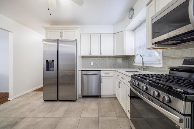 kitchen with sink, white cabinetry, light tile patterned floors, and appliances with stainless steel finishes