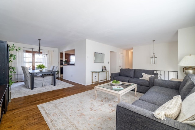 living room featuring a notable chandelier and dark wood-type flooring