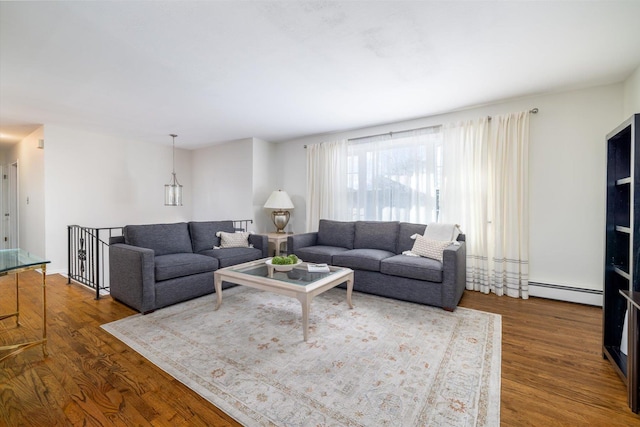 living room featuring dark wood-type flooring and a baseboard heating unit