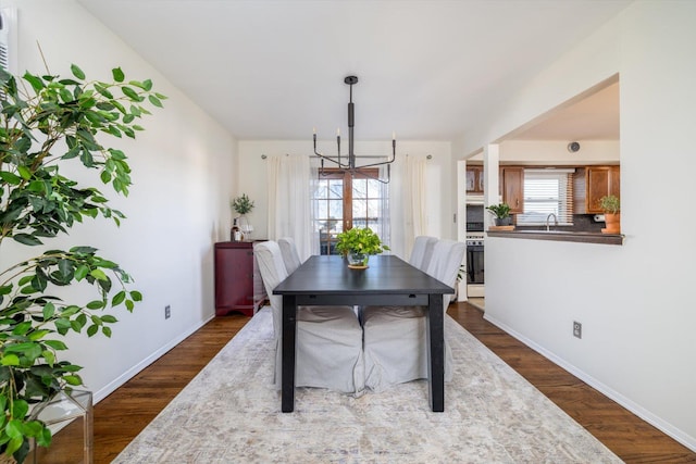 dining space featuring dark hardwood / wood-style floors and a chandelier