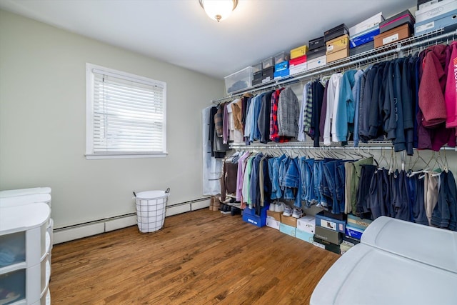 spacious closet featuring baseboard heating and hardwood / wood-style floors