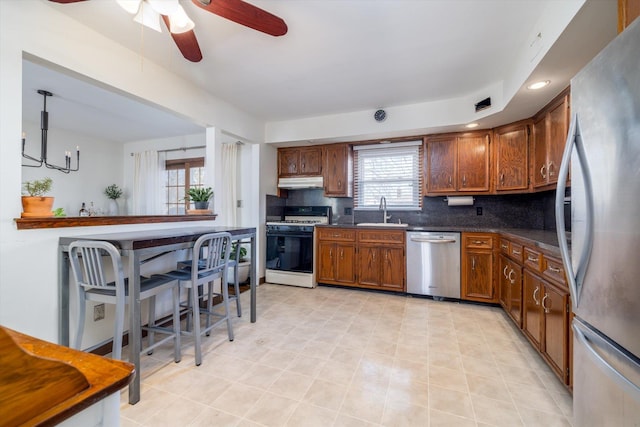 kitchen featuring ceiling fan, sink, backsplash, and appliances with stainless steel finishes