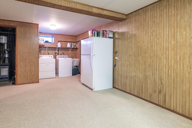 washroom featuring wood walls, light carpet, and independent washer and dryer