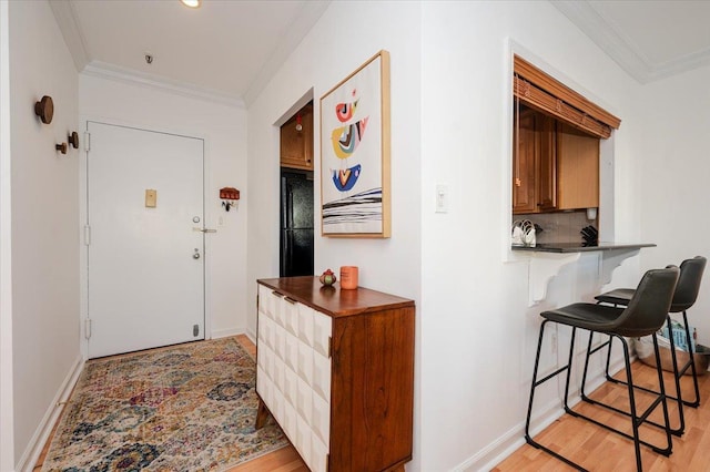 corridor featuring ornamental molding and light hardwood / wood-style floors