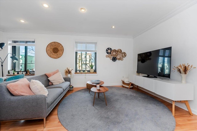 living room with a healthy amount of sunlight, wood-type flooring, and ornamental molding