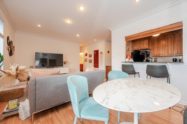 dining room with crown molding and light wood-type flooring