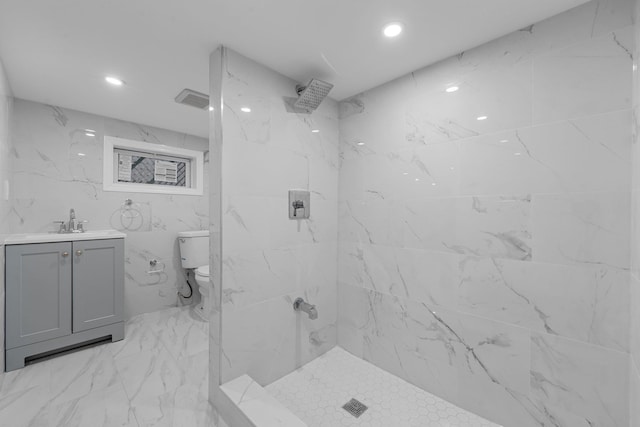 bathroom with vanity, toilet, and a tile shower