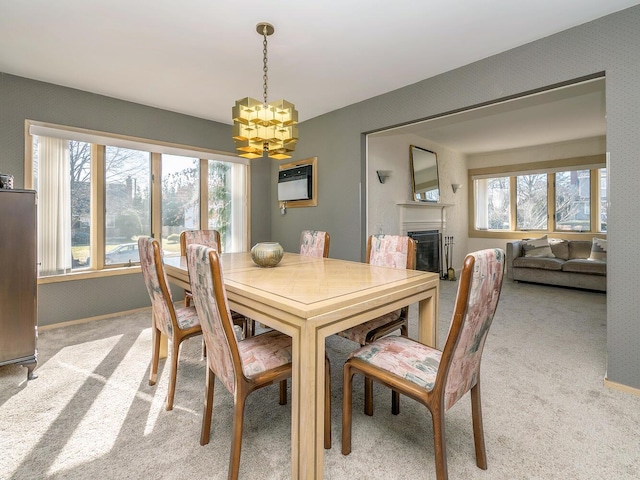 dining area with an inviting chandelier, light colored carpet, and a healthy amount of sunlight