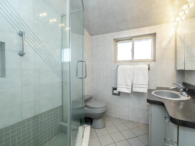 bathroom featuring tile patterned floors, toilet, an enclosed shower, tile walls, and vanity