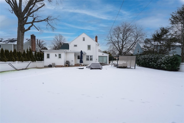 view of snow covered rear of property