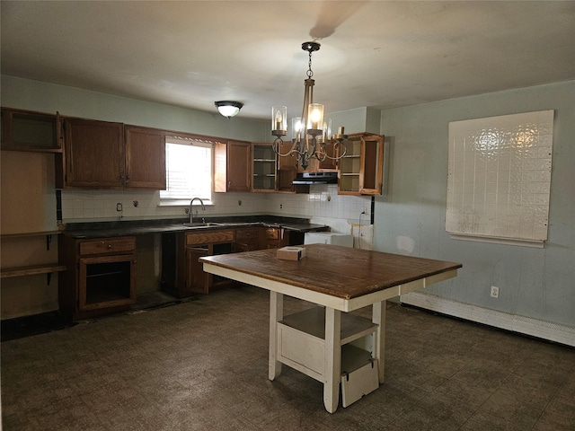 kitchen featuring decorative light fixtures, sink, and backsplash