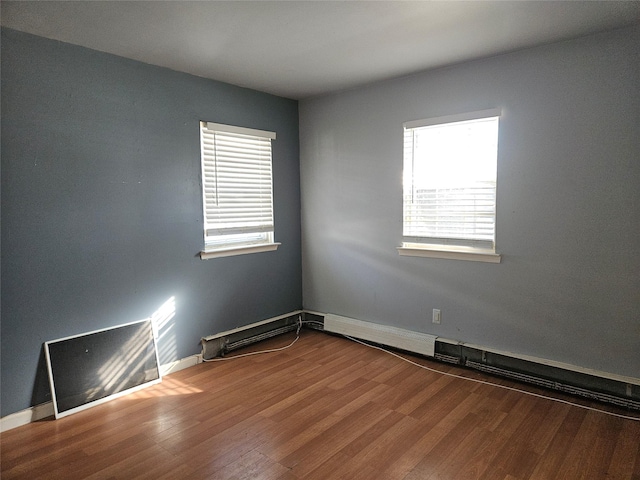 empty room featuring a wealth of natural light and wood-type flooring