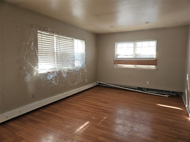 unfurnished room with a baseboard radiator and dark hardwood / wood-style floors