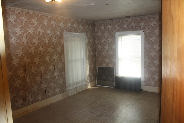 empty room featuring dark parquet flooring and radiator