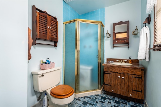 bathroom with an enclosed shower, vanity, and toilet