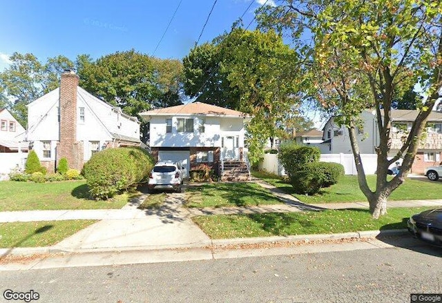 view of front of home with a garage and a front yard