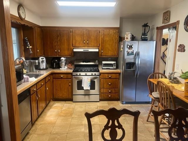 kitchen with sink, light tile patterned floors, and stainless steel appliances