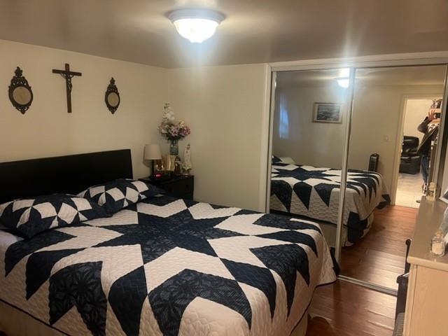 bedroom featuring dark hardwood / wood-style floors and a closet