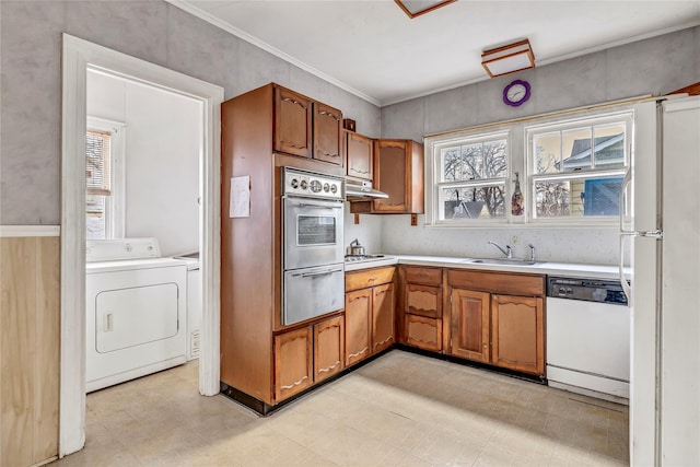 kitchen featuring sink, stainless steel appliances, crown molding, and separate washer and dryer