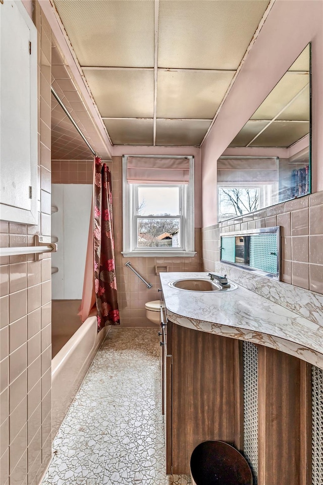 full bathroom featuring tile walls, toilet, shower / bath combination with curtain, and vanity