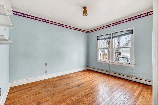 spare room featuring light wood-type flooring and baseboard heating